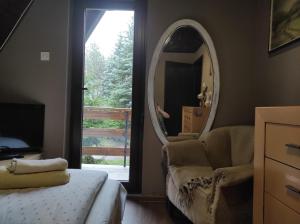 a bedroom with a chair and a mirror at Vila Vera in Zlatibor
