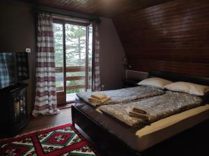 a bedroom with a bed and a large window at Vila Vera in Zlatibor