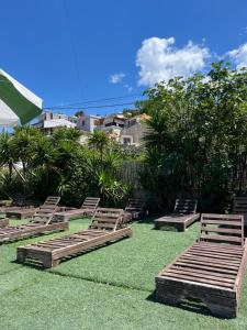 a group of wooden chairs sitting on the grass at Oasis on the Beach in Himare +1 photo