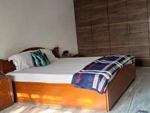 a bedroom with a bed with a wooden frame and wooden cabinets at Chinar Homes Amritsar in Amritsar +3 photos