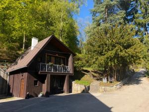 a house with a balcony on the side of it at Leśny Dworek Marianny 4 osobowy in Miedzygorze