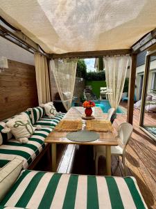 a room with a table and chairs and a pool at Jasmin House in Cenon