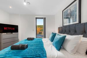 a bedroom with a bed with blue and white pillows at Duplex 2BR Flat with Parking Near Excellent Transport Links By Stay Aura Short Term Lets Brentford in Brentford