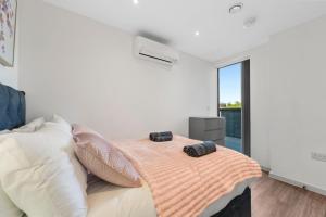 a bedroom with a bed with two pillows on it at Duplex 2BR Flat with Parking Near Excellent Transport Links By Stay Aura Short Term Lets Brentford in Brentford