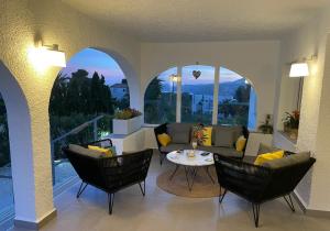 a living room with a couch and chairs and a table at Villa Aqua Vista in Jávea