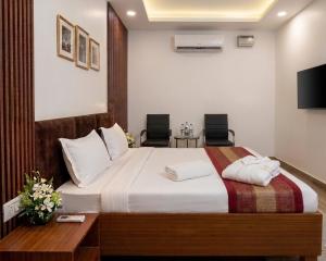a hotel room with a bed and two chairs at Hotel Sooryavanshi in Ayodhya