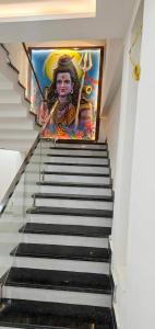 a staircase with a painting on the wall at Hotel Sooryavanshi in Ayodhya +2 photos