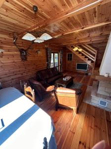 a room with a bed and a couch in a log cabin at Summer house near the forest in Dybki