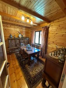 a dining room with a table and chairs in a cabin at Summer house near the forest in Dybki
