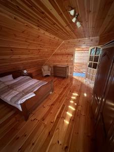 a bedroom with a bed in a wooden cabin at Summer house near the forest in Dybki