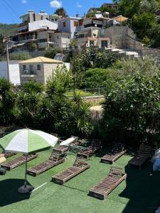 a group of lounge chairs and an umbrella on the grass at Oasis on the Beach in Himare