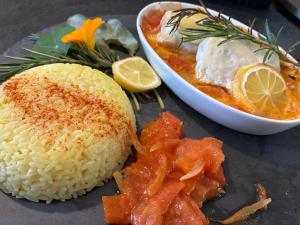 a plate of food with rice and a bowl of soup at U Sognu 3128 in Muro