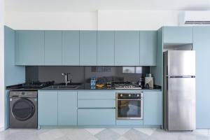 a blue kitchen with a stove and a refrigerator at Bay B Blu,Modern 1BR Chalet -Seaview in Ed Dkârîne +7 photos