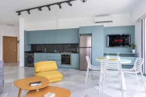 a kitchen with a table and chairs in a room at Bay B Blu,Modern 1BR Chalet -Seaview in Ed Dkârîne
