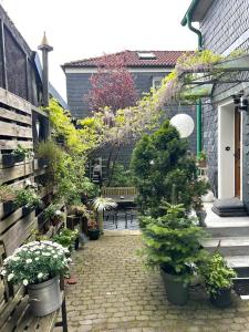 a garden with potted plants and a bench on a sidewalk at Fachwerkjuwel im Bergischen in Remscheid