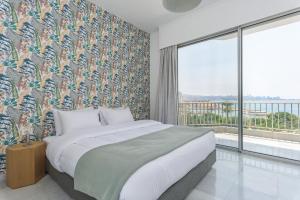 a bedroom with a large bed and a large window at Bay B Blu,Modern 1BR Chalet -Seaview in Ed Dkârîne