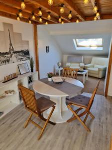 a living room with a table and chairs and a couch at Le Chaudron d'Or - 41m2 - Hyper Centre - Mezzanine - Clim - WIFI HD in Amiens