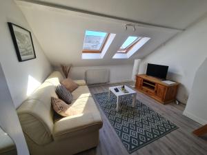 a living room with a couch and a tv at Le Chaudron d'Or - 41m2 - Hyper Centre - Mezzanine - Clim - WIFI HD in Amiens