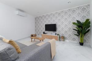 a living room with a couch and a tv at Villa Aurora in Livramento