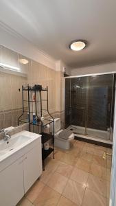 a bathroom with a sink and a toilet and a shower at Kauai Guest House in Parede +18 photos