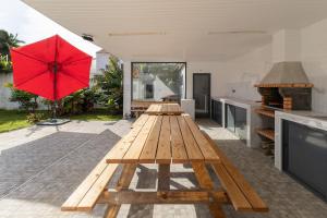 a picnic table with a red umbrella on a patio at Villa Aurora in Livramento