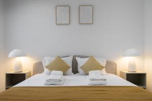 a bedroom with a bed with pillows and two lamps at Villa Aurora in Livramento