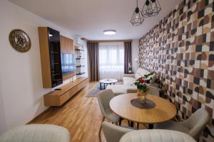 a living room with a table and chairs at Tilia Lux Wellnes &Spa in Čačak