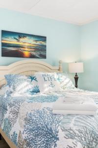 a bed with a blue and white comforter and pillows at Late August Labor Day Deals! Ocean Block Sleeps 6 Beach Gear in Ocean City