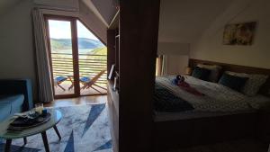 a bedroom with a bed and a view of a balcony at Panorama Apartment in Mavrovo