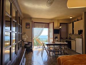 a living room with a table and a view of the ocean at Sea View Apartment with Terrace & Free Parking in San Lorenzo al Mare