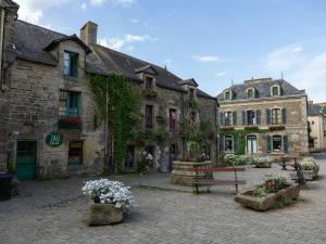 a group of buildings in a courtyard with flowers at Le Grand Rue Signature - Appartement coeur de ville, rue piétonne in Bergerac