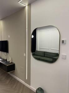 a mirror on a wall with a couch in a room at Soho Apartment Fial in Bacău