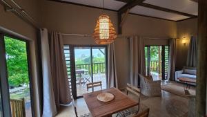 a living room with a table and a view of a porch at Terganic Farmstay in Grand Sable