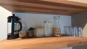 a shelf with glass jars and a coffee maker on it at Terganic Farmstay in Grand Sable +18 photos