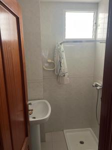 a white bathroom with a sink and a toilet at Andaluz in La Mamola