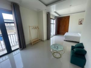 a bedroom with a bed and a couch and a table at Home Me 2 in Dong Hoi