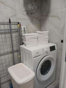 a washing machine in a bathroom with a pile of towels at Apartman Herceg in Ljubuški