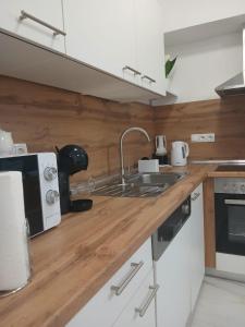 a kitchen with a sink and a microwave at Apartman Herceg in Ljubuški