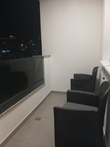 a room with two chairs and a large window at Apartman Herceg in Ljubuški