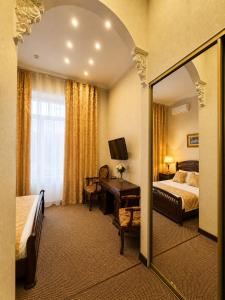 a hotel room with a bed and a desk and a mirror at Oreanda Hotel in Odesa