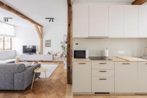 a kitchen and living room with white cabinets and a couch at Vakantiewoning Gast in Borgloon