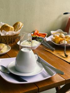 a table with a tea pot and plates of food at Pousada Descanso Do Preguiça in Barreirinhas