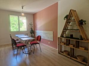 a dining room with a table and chairs and a shelf at Le Nid Cabailla in Coimères