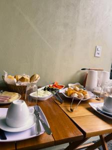 a wooden table with plates of food on it at Pousada Descanso Do Preguiça in Barreirinhas