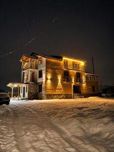 a house is lit up in the snow at night at Ninama in Mestia
