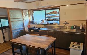a kitchen with a wooden table and a sink at 花子のいえ hanako's house in Amidaji