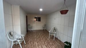 a room with three chairs in a room with white tiles at Seu lar em Bonito-PE in Bonito