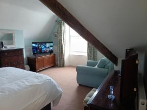 a bedroom with a bed and a chair and a television at Bron Orme Private Hotel in Llandudno