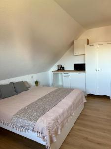 a bedroom with a bed and a white cabinet at Ferienwohnung Carla in Weißensee