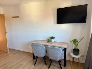 a table with two chairs and a television on a wall at Ferienwohnung Carla in Weißensee